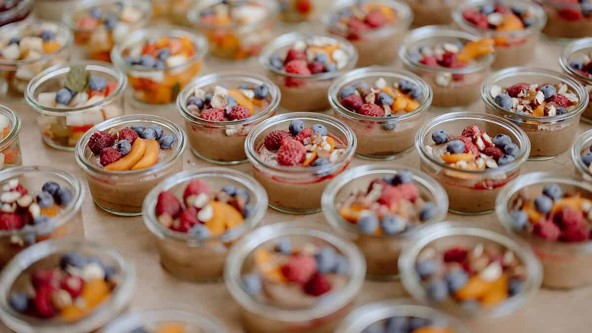 Detalojede Gläser voller frischer Beeren und Früchte für Hochzeitsfeier.